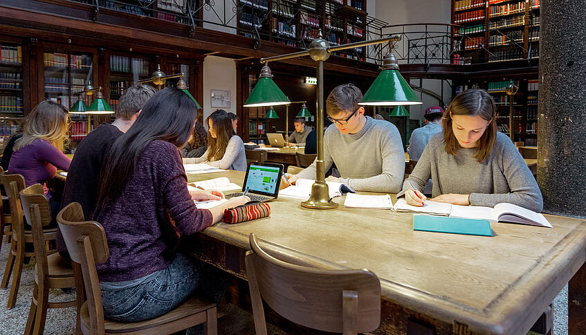 Students studying in the large reading room of the main library.