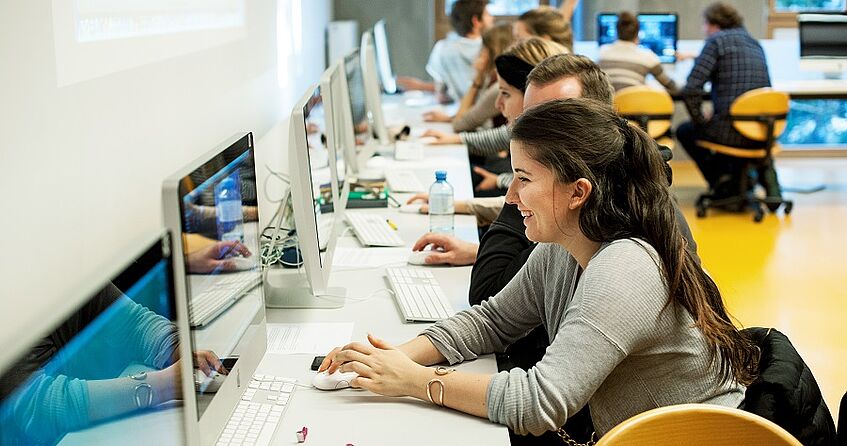 Studierende sitzen in einem Computerraum.