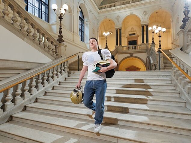 Student im Football Outfit geht die Treppen herunter